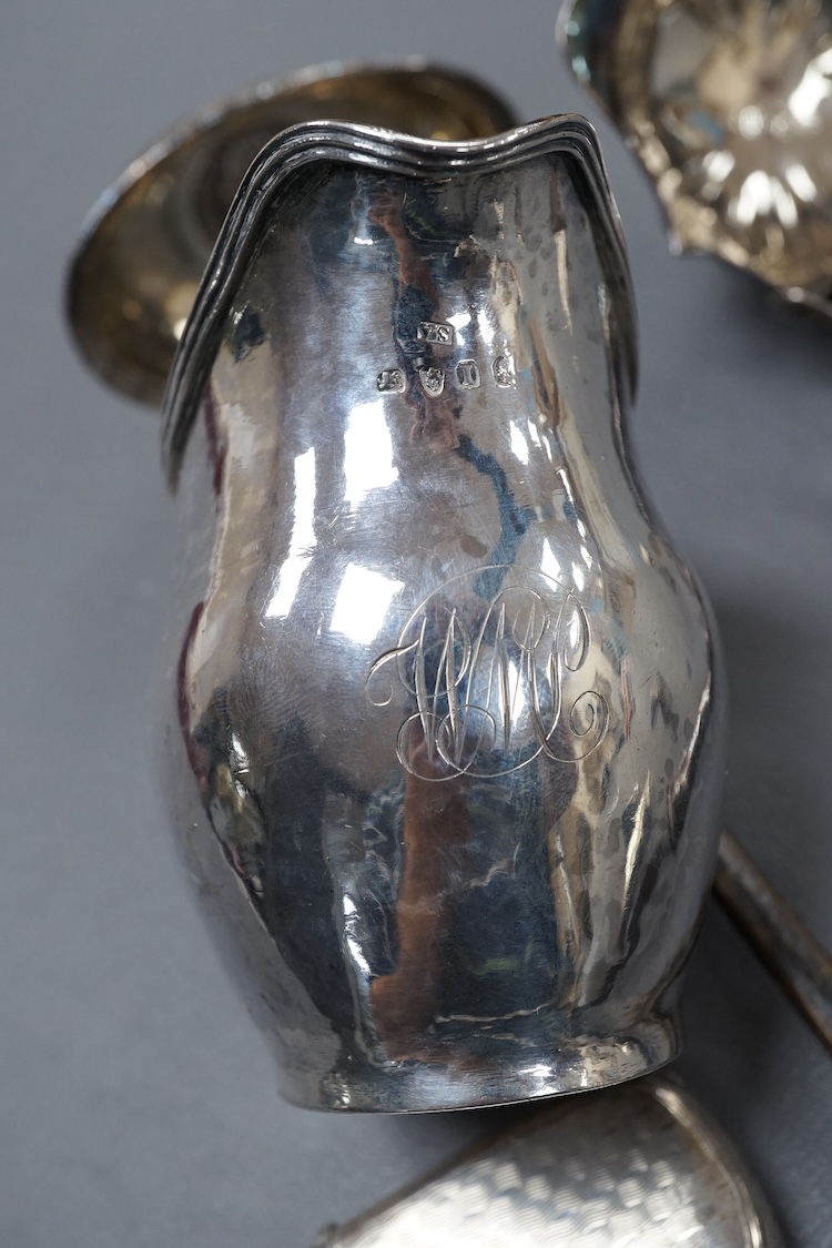 A small group of collectable silver including a George III silver cream jug, London, 1804, height 95mm, three silver vesta cases, two pill boxes, an envelope stamp case, two Georgian toddy ladles, one unmarked, together